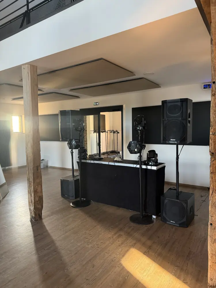 Estrade, enceintes et lyres installées dans une salle